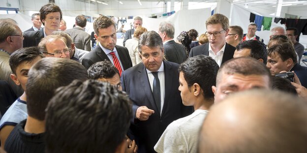 Sigmar Gabriel umgeben von Reportern und Flüchtlingen in Heidenau Sigmar Gabriel umgeben von Reportern und Flüchtlingen in Heidenau