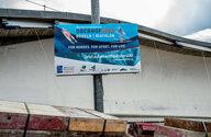 Ein Werbeschild für die Rodel- und Biathlon-WM vor der Bobbahn