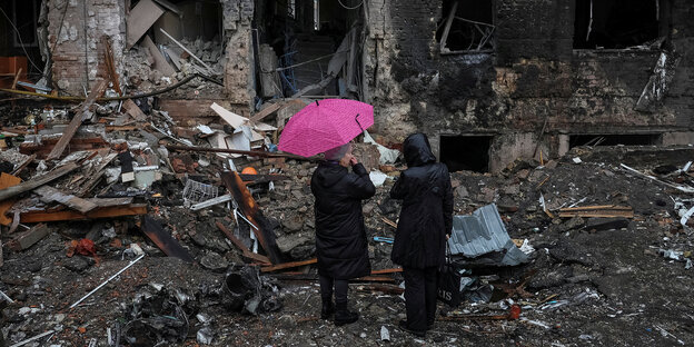 Zwei Menschen vor einem zerstörten Haus