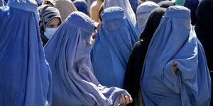 In hellblaue Burkas verhüllte Afghaninnen warten im August 2022 in Kabul auf die Verteilung von Lebensmittelrationen.