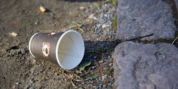 Ein weggeworfener Kaffeebecher liegt auf der Straße Ein weggeworfener Kaffeebecher liegt auf der Straße