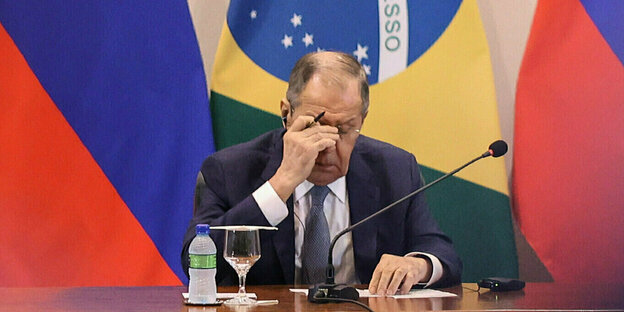 Russian Foreign Minister Lavrov between flags of Russia and Brazil
