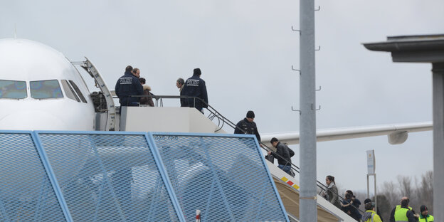 Menschen auf einer Flugzeugtreppe Menschen auf einer Flugzeugtreppe