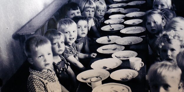An undated photo shows children sitting at a dining table in Colonia Dignidad