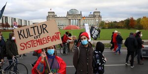 Menschen demonstrieren vor dem Reichstag in Berlin, jemand trägt ein Schild mit der Aufschrift "Kultur ist sytemrelevant"