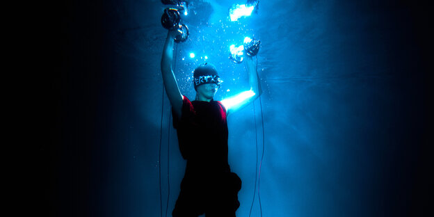 Tzusing unter Wasser mit Hanteln in Luftblasen