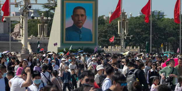 A large crowd gathers in Tiananmen Square, where a portrait of Sun Yat-sen hangs, during May Day.