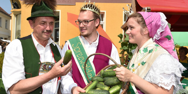 Drei Menschen in Trachten mit Gurken Drei Menschen in Trachten mit Gurken