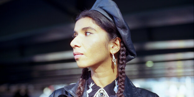 Portrait of the musician Nabihah Iqbal with a braid and a leather cap