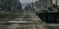 Eine leere Straße, am rechten Bildrand ein Panzer