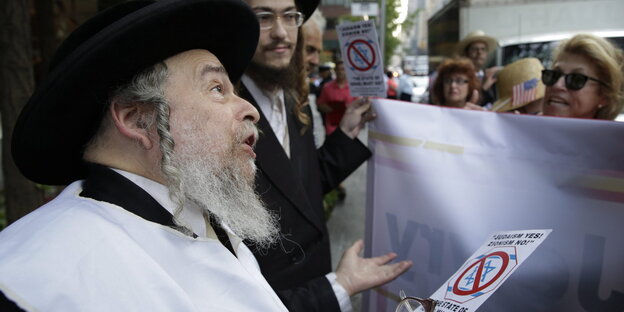 Ein Rabbiner spricht auf der Straße mit Passanten Ein Rabbiner spricht auf der Straße mit Passanten
