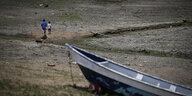 Ein Boot und Spaziergänger auf einem trockenen Flussbett