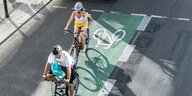 Das Bild zeigt zwei Radfahrer auf einem Radstreifen auf der Straße.