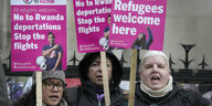 Frauen stehen mit Plakaten in einer Reihe. Darauf stehen Sätze wie: No to Rwanda deportations stop the flights