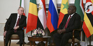 Russlands Präsident Putin und Südafrikas Präsident Ramaphosa vor Flaggen.