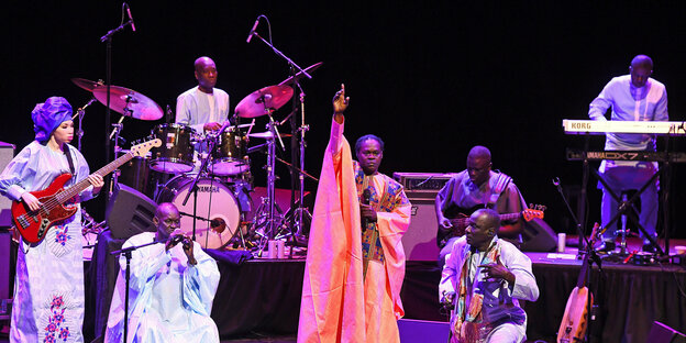 Eine siebenköpfige Band, im Zentrum der Musiker und Star Baaba Maal im bunten Kaftan