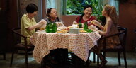 Vier vietnamesische Frauen sitzen am Tisch und bereiten Essen zu