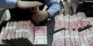 Ein Bankangestellter zählt chinesische Banknoten