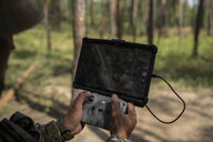 Soldat bedient Drohne im Wald