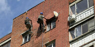 Arbeiter reparieren einen Hausfassade