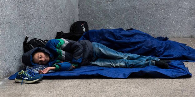 Menschen im Schlafsack, in einer Ecke liegend. Menschen im Schlafsack, in einer Ecke liegend.