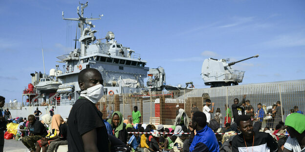 Migranten warten darauf, von der Insel Lampedusa auf das Festland gebracht zu werden.