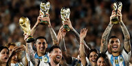 Argentinischen Spieler jubeln mit mehreren Weltmeisterpokalen.