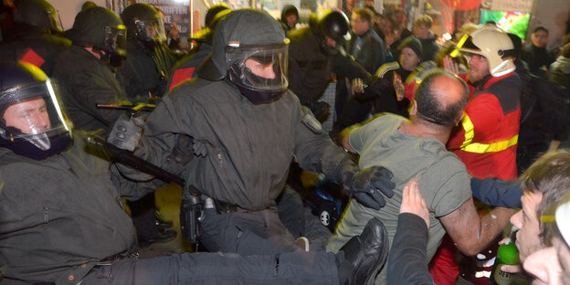 Polizisten treten einen Demonstranten Polizisten treten einen Demonstranten