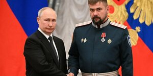 Putin gibt einem Uniformierten die Hand