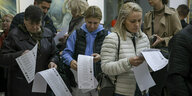 Menschen halten Wahlzettel in den Händen