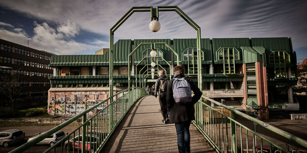 Studierende gehen über die Fußgängerbrücke zur Hauptmensa in Hannover