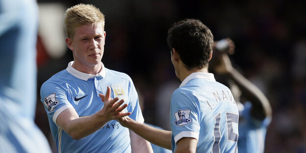 Kevin de Bruyne klatscht mit einem Mitspieler ab.