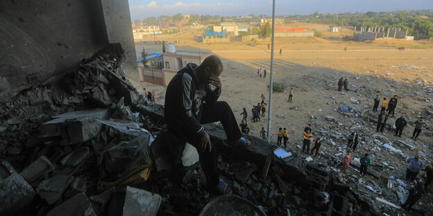 A man sits in despair in a bombed-out house in Khan Yunis in the Gaza Strip