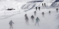 Viele Skifahrere und Skifahrerinnen auf einer verschneiten Piste