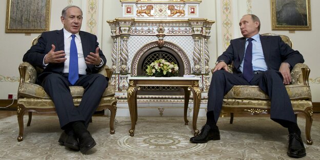 Putin und Netanjahu sitzen in einem Saal, im Hintergrund ein Ofen. Putin und Netanjahu sitzen in einem Saal, im Hintergrund ein Ofen.