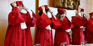 Vier Personen mit roten Roben im Bundesverfassungsgericht