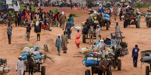 Menschen flüchten auf Pferdewagen und zu Fuß vor der Gewalt in West Dafur.