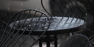 Das Bild zeigt Regen, wie er auf einen Tisch fällt