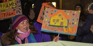 Protestaktion gegen die Kündigung der Räume Karlsgartenstraße 6: eine Frau hält ein selbst gemaltes Schild bei einer Demo hoch: "Räume für uns" steht darauf