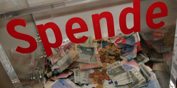 In einer durchsichtigen Spendenbox liegen Geldscheine und Münzen. In einer durchsichtigen Spendenbox liegen Geldscheine und Münzen.