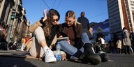Zwei junge Frauen sitzen auf einer Straße in Belgrad