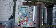 Ein Automat für Spritzen in Kiel, im Hintergrund geht ein Mann vorbei.