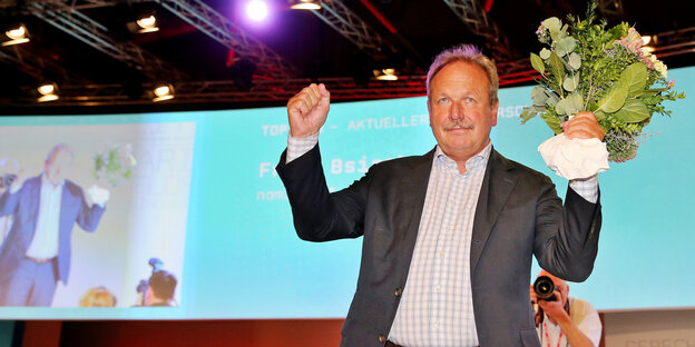 Verdi-Chef Bsirske hat einen Blumenstrauß in der Hand und freut sich Verdi-Chef Bsirske hat einen Blumenstrauß in der Hand und freut sich