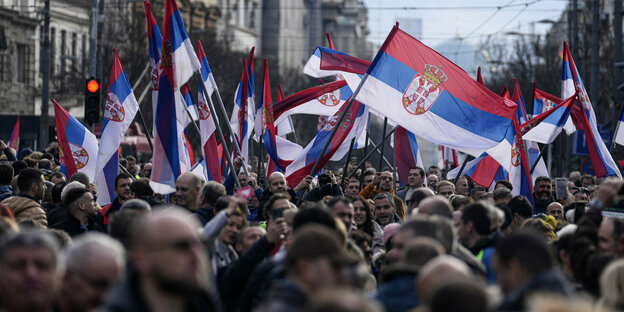 Demonstranten schwenken am 30.12. in Belgrad serbische Flaggen während einer Demonstration gegen mutmaßlichen Wahlbetrug.