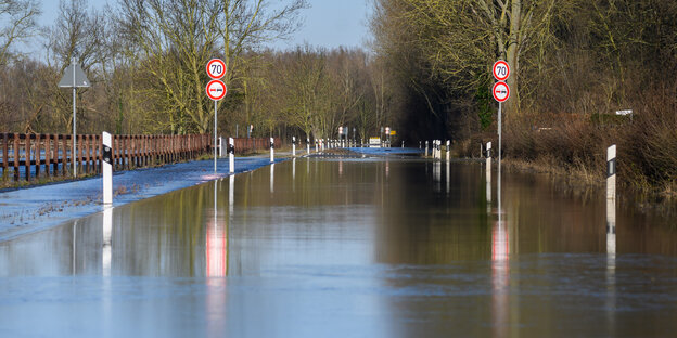 Überflutete Straße mit Tempo-70-Schildern