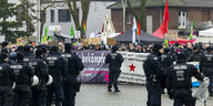Etwa 2400 Gegendemonstranten schreien Parolen und zeigen Plakate gegen die AfD, während der Neujahrsempfang der AfD Duisburg stattfindet, und die Polizei bewacht den Veranstaltungsort.