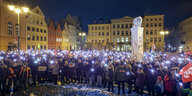 Menschenmenge zündet Lichter mit dem Handy auf dem Marktplatz der Altstadt von Schwerin