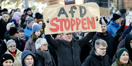 Ein Teilnehmer auf der Demo in Erfurt hält ein Schild mit der Aufschrift "AfD stoppen" hoch