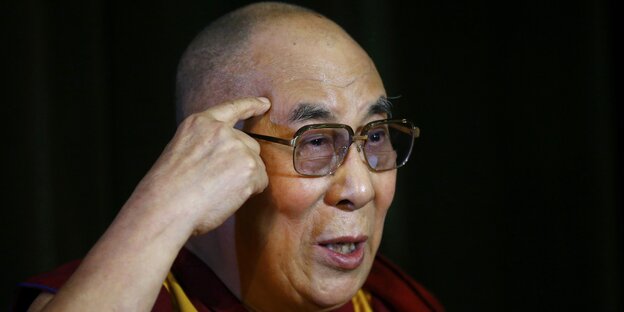 Der Dalai Lama fasst sich an den Kopf Der Dalai Lama fasst sich an den Kopf