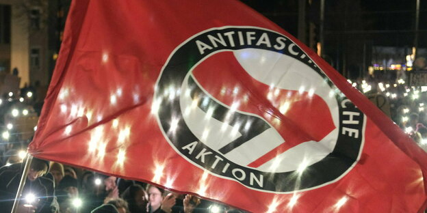 Antifa flag in front of a sea of ​​lights